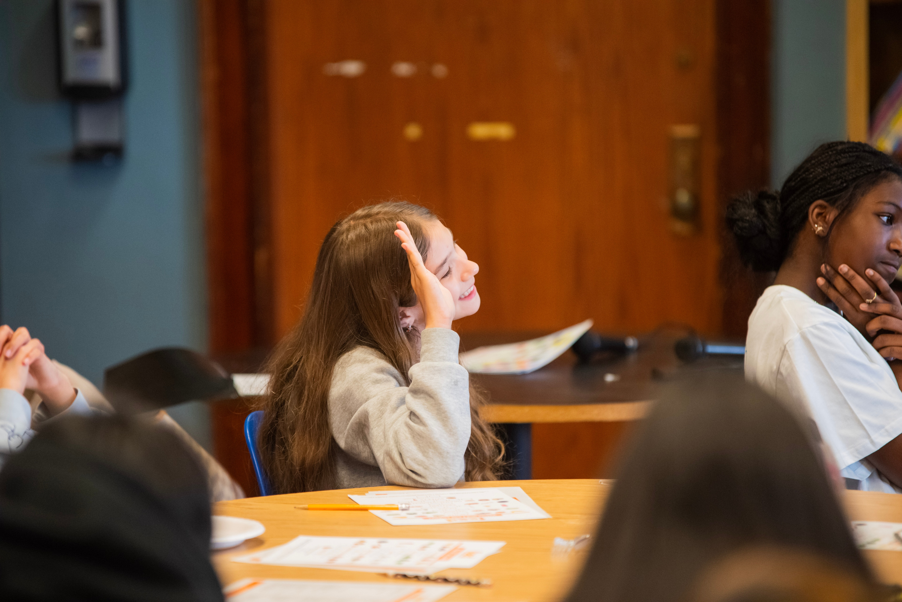 Talcott student raising a hand during a workshop session.