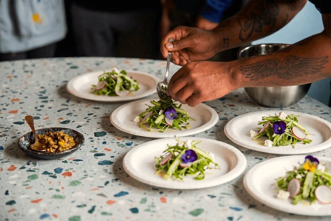 Chef plating a dish made from student-grown produce at an HVP community workshop.